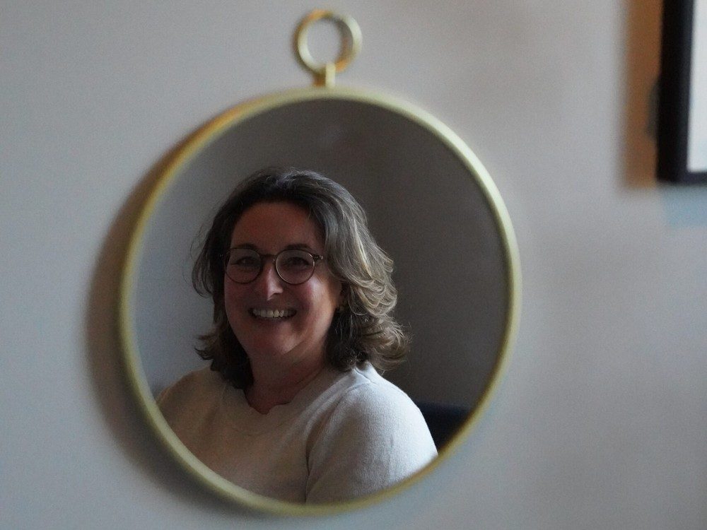 Frederique Leemkuil in een spiegel, glimlachend, bij Leemkuil Energie & Balans in Vleuten-De Meern"
